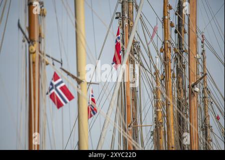 Norwegian flags hanging from the masts of old wooden sailing boats Stock Photo