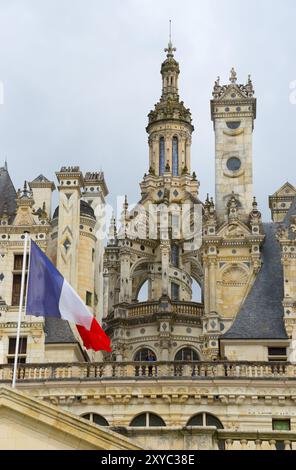 Detailed view of a historic castle with elaborate decorations and a French flag in the foreground, Chambord Castle, Chateau de Chambord, Loire Castle, Stock Photo