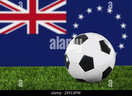 The Cook Islands flag and soccer ball on the green grass Stock Photo