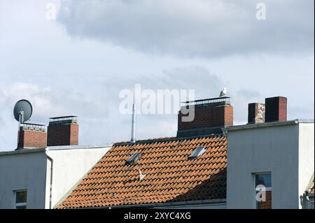 Roof of a row of houses with parabolic reflector. Row of houses Stock Photo