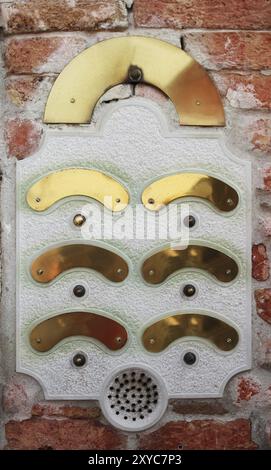 An intercom doorbell panel on the brick wall Stock Photo