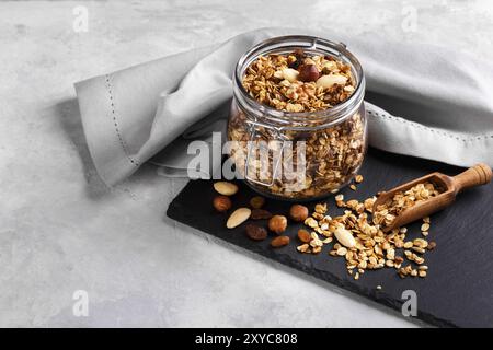 Homemade healthy granola made of oats nuts and fruits on black stone background copy space Stock Photo