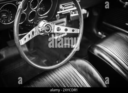 Steering wheel of a Vintage Chevy car showing the interior of the Car with dashboard and seats. Black and white photo, Selective focus, Canada BC, Sep Stock Photo