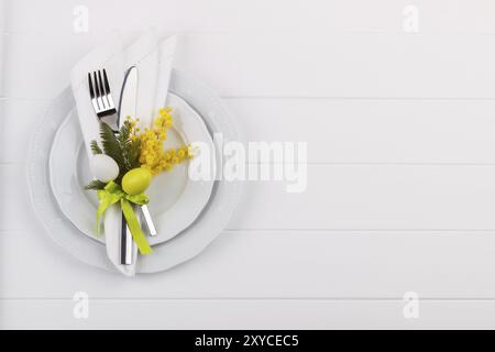 Easter dinner table setting on white wooden table, festive holiday background top view Stock Photo