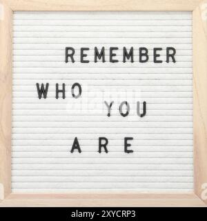 Letter board with phrase Remember who you are on white background, top view Stock Photo