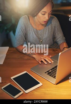 Business woman, night and laptop in office for working overtime, deadline and creative online project. Female graphic designer, computer and research Stock Photo