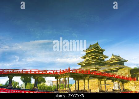 A painterly mirror image of Matsumoto Castle upside down seen as water surface reflection on a blue sky day in Nagano Prefecture, Japan. Horizontal Stock Photo