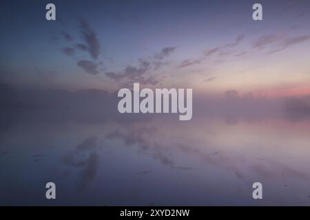 Calm, warm misty sunrise in summer over river Stock Photo