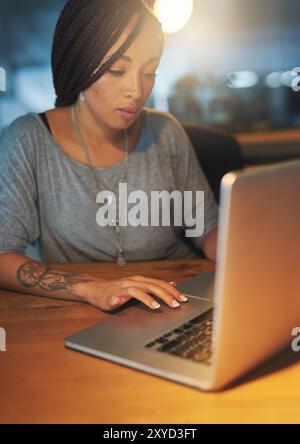 Business woman, night and computer in office for working overtime, deadline and creative online project. Female graphic designer, laptop and research Stock Photo