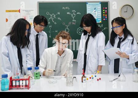 Collaborating Students Conducting Chemical Experiment in Laboratory Stock Photo