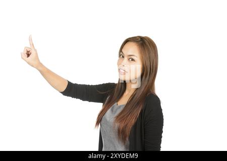 Side profile of stunning Asian woman in black sweater with light brown hair, arm extended index finger pushing imaginary button looking at camera. Tha Stock Photo