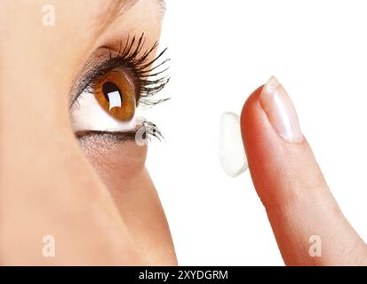 Closeup of a woman inserting a contact lens in her eye Stock Photo