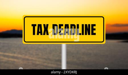 Tax deadline message written on yellow sign with blurry lake background. Conceptual tax deadline symbol. Copy space. Stock Photo