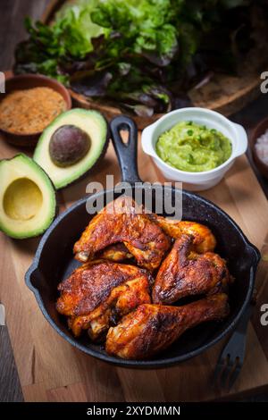 Grilled chicken legs and wings with guacamole, frish salad and spicies Stock Photo