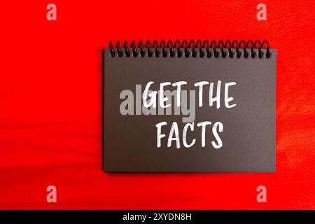 Get the facts message written on black notebook page with red background. Conceptual get the facts symbol. Copy space. Stock Photo