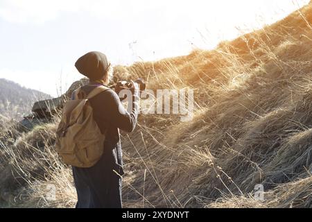 Woman hipster-photographer with dslr camera. Stylish girl in sunglasses with a camera on the nature Stock Photo