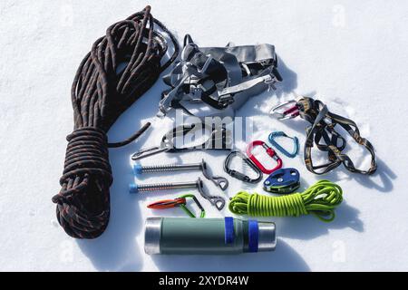 Close-up of winter climbing equipment on fresh snow on a sunny day. Carbines with a rope gazebo and zhumar as well as other adaptations when practicin Stock Photo