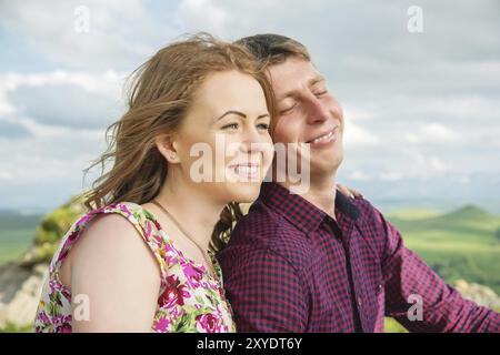 Young married couple happily laughing in nature against the background of rocks and stones. Concept of a happy young family Stock Photo