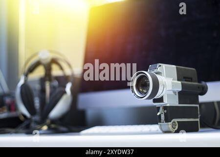 Vintage old movie camera, computer for cutting in the blurry background. Sunshine Stock Photo
