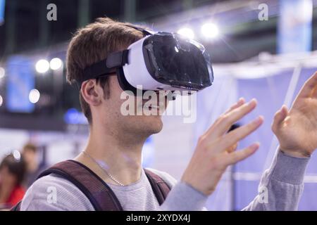 Young man is using virtual reality glasses on an expo Stock Photo
