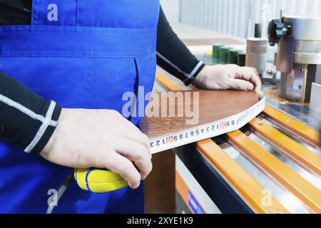 Closeup of Carpenter's hands using one meter in a cottage workshop Stock Photo