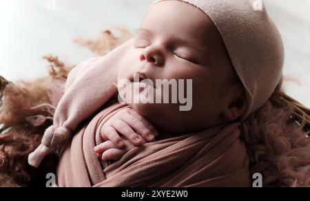 Newborn, Adorably Swaddled In A Blanket And Wearing A Hat, Sleeps Peacefully Stock Photo