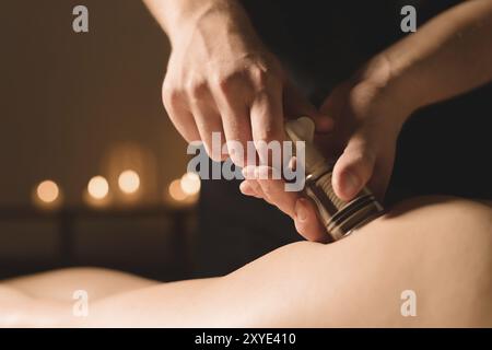 Close-up Hardware cosmetology. Vacuum massage procedure. Male hands install vacuum banks. Close-up of anti-cellulite treatment of a young woman Stock Photo