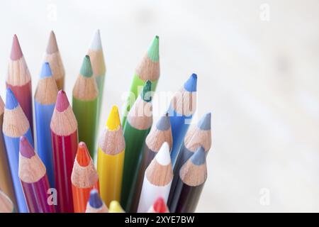 Colored pencils in a can on rustic wooden table, white background Stock Photo