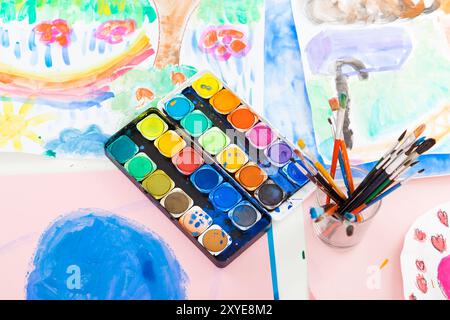 Watercolours and brushes with paintings Stock Photo