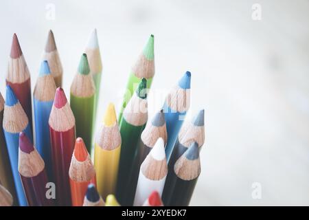 Colored pencils in a can on rustic wooden table, white background Stock Photo