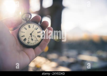 Hand held stop watch outdoors, autumn, blurry background Stock Photo
