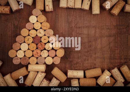 Chtistmas or New Year wine design template. A Christmas tree of wine corks, shot from the top on a dark wooden background with a place for text and lo Stock Photo