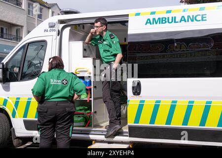 St John Ambulance first aid volunteers, man with glasses in green and black uniform looking out from ambulance. Ballycastle, UK - August 26th, 2024. Stock Photo