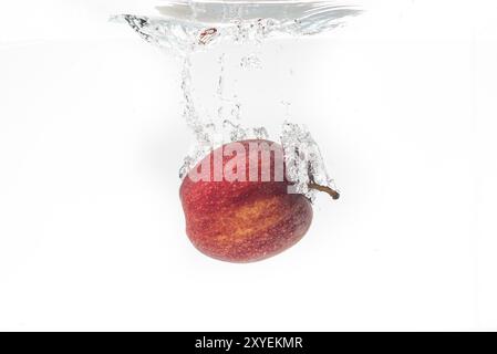 Apple falls under water with a splash Stock Photo
