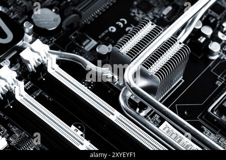 Computer motherboard closeup with copper heatsink reflectors and memory slots Stock Photo