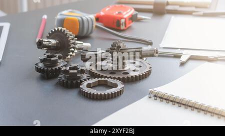 The gear set is placed on the workbench of a team of factory mechanical engineers to study and design the working system of the mechanical gearbox in Stock Photo