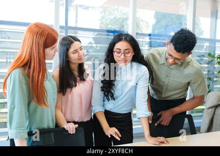 Multiethnic teamwork collaborating on business strategies, standing around a table and brainstorming in a modern office Stock Photo