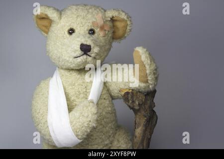 Injured teddy with stick Stock Photo