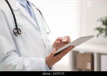 Doctor using tablet in hospital, closeup view Stock Photo