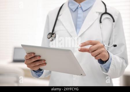 Doctor using tablet in hospital, closeup view Stock Photo