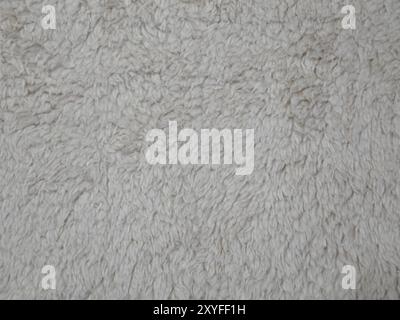 Detail of off-white wool-type fleece material is shown in a closeup view. Stock Photo