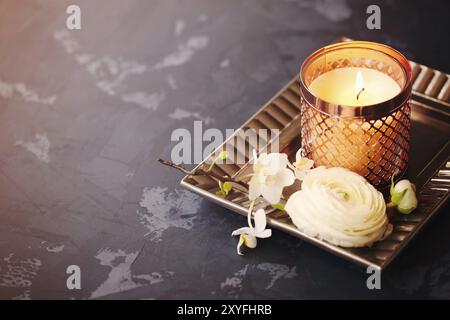 Festive invitation card with beautiful flowers and tray with burning candle on the dark background Stock Photo