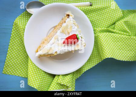 Piece of carrot cake with icing and little carrot on wooden background Stock Photo