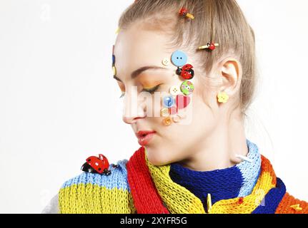 Profile portrait of a young blond woman with creativity hairstyle with colored buttons and fashion make up Stock Photo