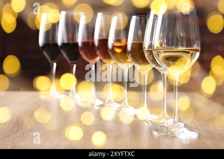 Different tasty wines in glasses on table. Bokeh effect Stock Photo