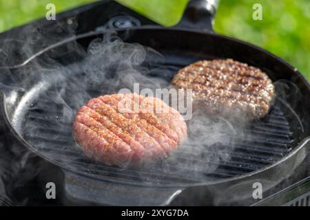 fresh burger meat patty on grill pan Stock Photo