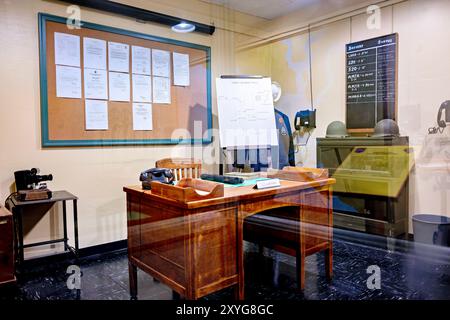 Battery Status Board at Fort Moultrie Command Post | SULLIVAN'S ISLAND, S.C. — A restored duty officer's desk at Fort Moultrie sits beneath a chalkboard tracking the readiness of individual gun batteries by name and caliber, from "Lord — 2, 3-inch RF" to "Mobile — 2, 155mm." The display recreates the World War II harbor defense command post, when Charleston's ring of coastal batteries stood on constant alert against Axis submarines and surface raiders. Stock Photo