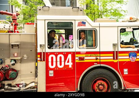 FDNY truck with young fire fighters in downtown New York ready to go. The bravest. Fighting the fire. Stock Photo