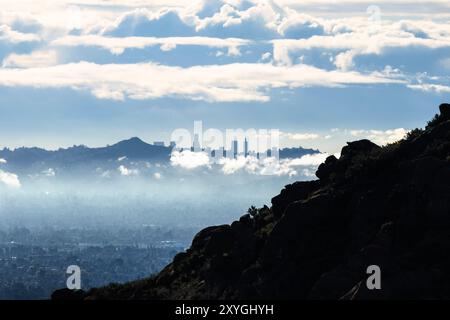 Downtown Los Angeles towers peaking over Santa Monica Mountains ridge with clearing storm clouds.  Photo taken in Rocky Peak Park in Chatsworth Califo Stock Photo