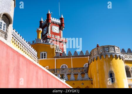 SINTRA, Portugal — The ornate red turret clock tower of Pena Palace stands out against the sky, showcasing the vibrant colors and eclectic Romanticist architecture of this 19th-century royal residence. This distinctive feature epitomizes the fairytale-like charm that makes Pena Palace a must-see landmark in Sintra. Stock Photo